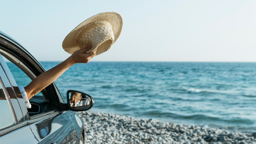 Mujer en coche de alquiler con vista a la playa en Costa Rica